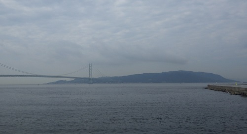 正面に淡路島の島影、左に明石海峡大橋が見える。