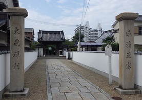 二本の石柱の向こうに大蔵院の山門が見える。