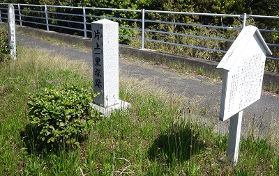 国道の横に片上一里塚跡を示す新しい石の標柱。手前に説明板。