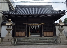 稲爪神社の瓦葺きの山門。両側に常夜燈。