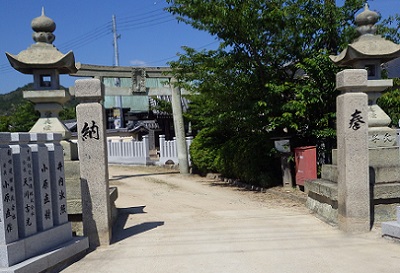 玉垣と常夜燈。その先に鳥居が見えて、さらにその奥に神社の建物