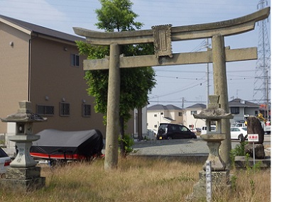 生石神社の鳥居。周りは住宅街。左手前に常夜燈がある。