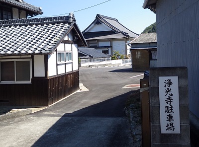 浄光寺駐車場の看板があり、その先にお寺の建物が見える